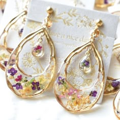 the earrings are decorated with flowers and gold leafy details, along with a card that says have a nice day