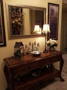 a wooden table topped with a mirror and two lamps