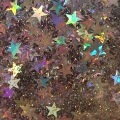 many different colored stars are scattered on the ground in this image, and there is no image here to provide a caption for