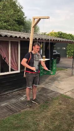 a man holding onto a kite in front of a house