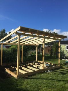 a wooden structure sitting on top of a lush green field