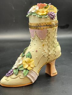 a close up of a shoe with flowers on the top and bottom, sitting on a black surface