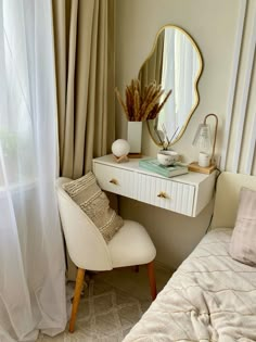 a white chair sitting next to a small desk with a mirror on top of it