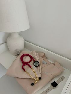 a pair of red scissors sitting on top of a piece of cloth next to a lamp