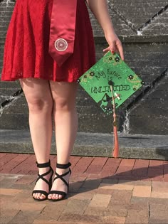 a woman in a red dress is holding a green sign