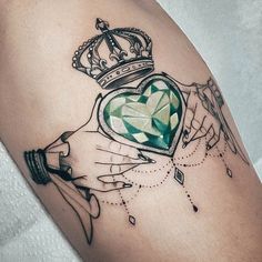 a woman's arm with a crown on it and a heart in the middle