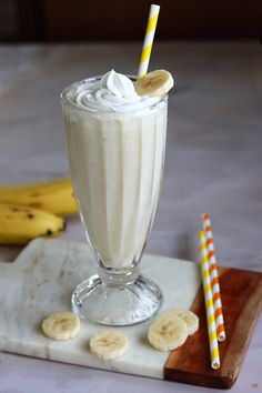 a banana milkshake with whipped cream and sliced bananas