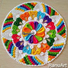 this is an image of a colorful art work on the floor with beads and thread