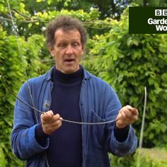 a man is holding two wires in his hands and making a funny face with the words garden world above him