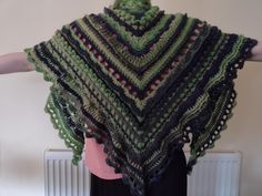 a woman wearing a green and black crocheted shawl