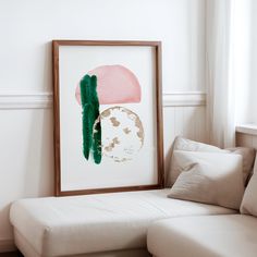 a white couch sitting next to a painting on the wall