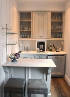 a kitchen with two stools at the bar