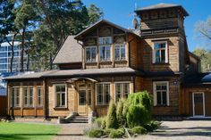 a large wooden house with lots of windows on it's sides and trees in the background