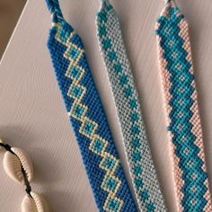 two beaded bracelets sitting on top of a table