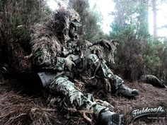 a man in camouflage sitting on the ground