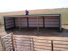 a man standing on top of a metal structure in the middle of an open field