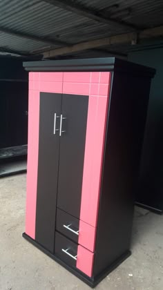 a pink and black cabinet sitting in a garage