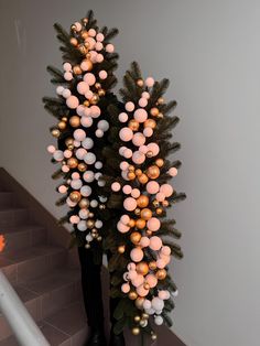 two tall black vases with christmas lights on them sitting on the ground next to some stairs