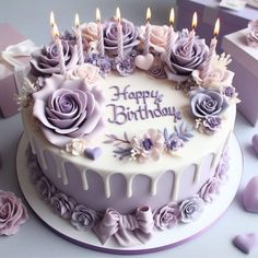 a birthday cake decorated with purple flowers and candles