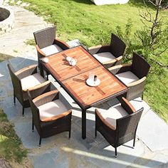 an outdoor dining table and chairs set up on a patio with grass in the background