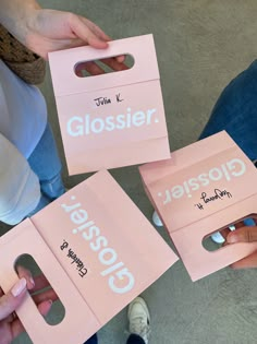 three people holding pink shopping bags with the words glosses on them