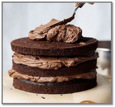 a cake with chocolate frosting on top and a spoon in the middle is being drizzled