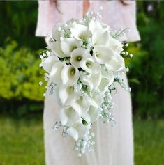 a bride holding a bouquet of white flowers