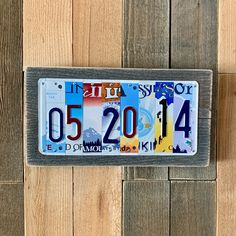 a license plate is hanging on a wooden wall