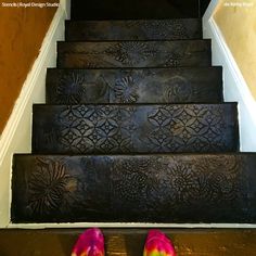 a pair of pink shoes sitting on top of a set of stairs next to a wall