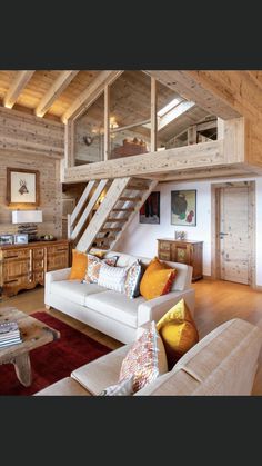 a living room filled with furniture and lots of wooden walls next to a lofted ceiling