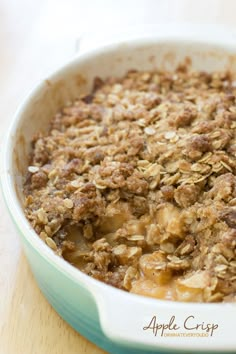 an apple crisp in a blue dish on a wooden table