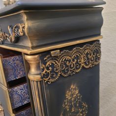 an ornate blue and gold cabinet with drawers