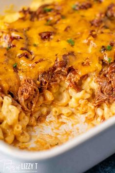 a casserole dish with meat, cheese and noodles in a white baking dish