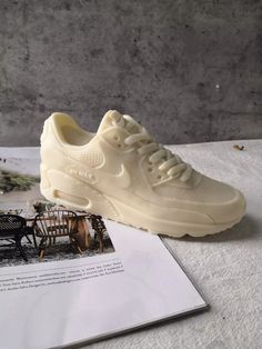 a pair of white shoes sitting on top of a table next to an old photo