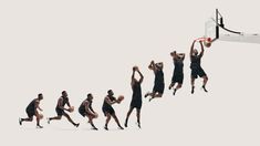 a group of men playing basketball against each other in front of a white background,