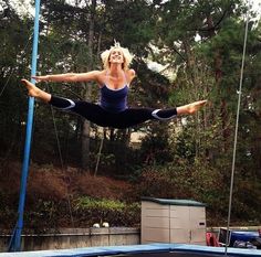 a woman on a trampoline doing aerial tricks