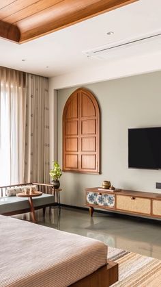 a bed room with a neatly made bed and a flat screen tv on the wall