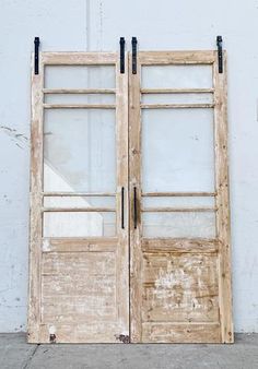 an old wooden door with glass panels on the front and side doors are open to reveal a white wall