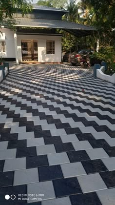 a house with black and white checkered tiles on the front yard, in an area that looks like it has been cleaned