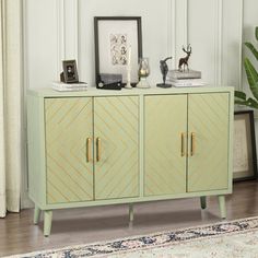 a green cabinet with two doors and some pictures on it next to a rug in front of a window