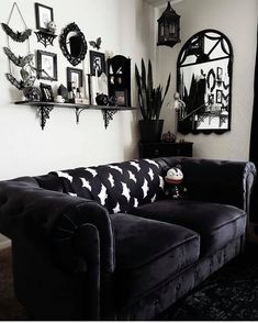 a black and white living room with lots of pictures on the wall above the couch