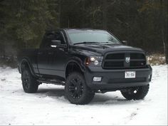 a black truck is parked in the snow