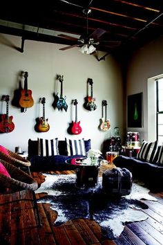 a living room with guitars on the wall