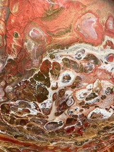 an abstract painting with red, brown and white colors on it's surface is shown