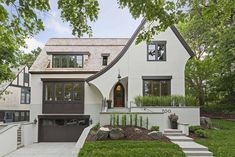 a white house with black garage doors and windows