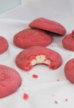 some red cookies with white frosting are on a table