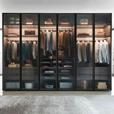 an open closet with clothes hanging on the walls and drawers in front of it,