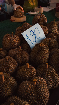 a pile of durian fruit sitting on top of a green table covered in writing