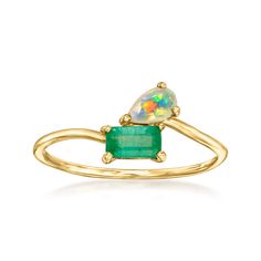 a yellow gold ring with an opal and emerald stone in the center, on a white background