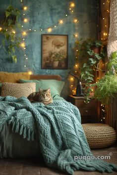 a cat laying on top of a bed covered in green blankets and pillows next to a potted plant